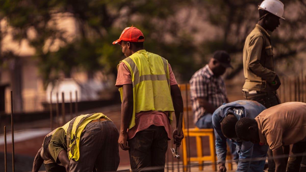 Builder in a hi-vis vest checking a phone on a building site