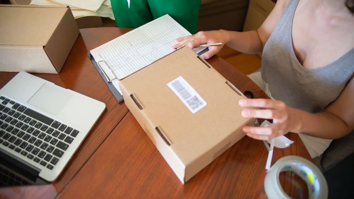 Shop owner packing a customer order at the counter of an independent store