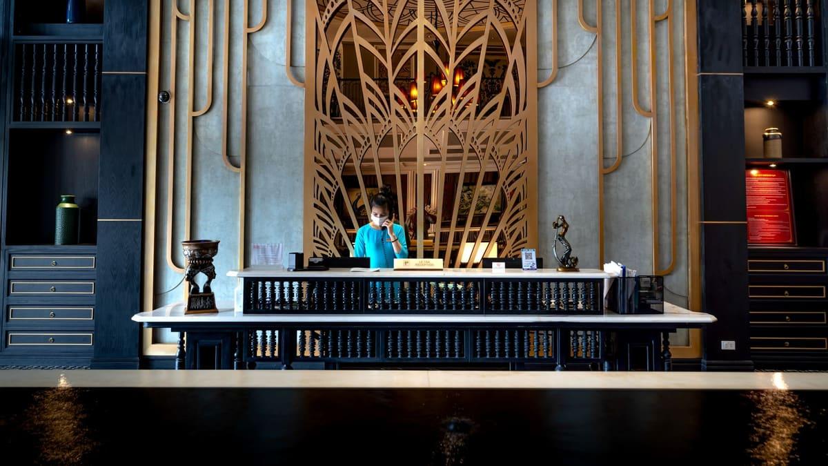 Member of staff working at the reception desk of a small hotel